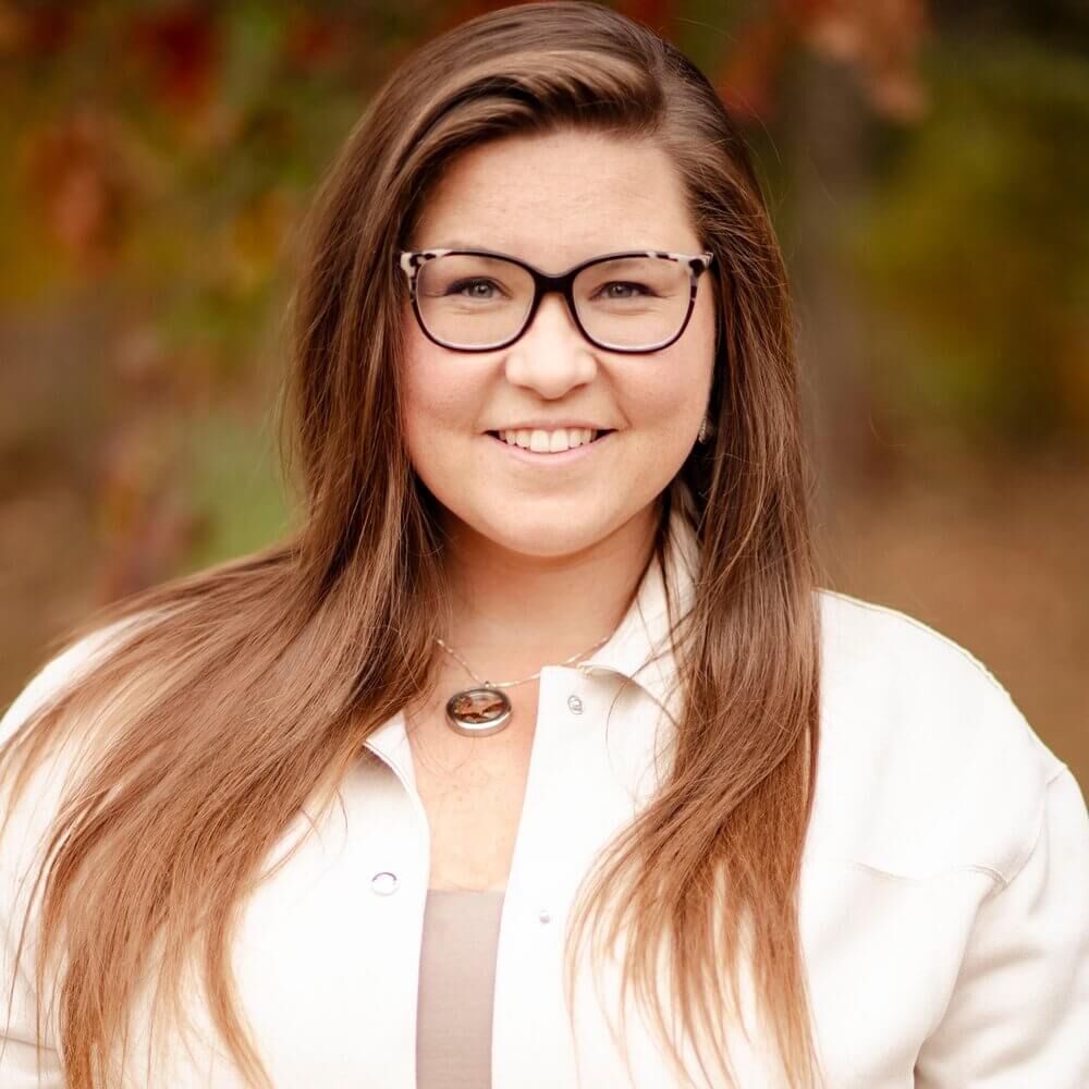 Rachel Straughen, Education Director at Grand Traverse Conservation District, smiling in a professional headshot with autumn foliage in the background.